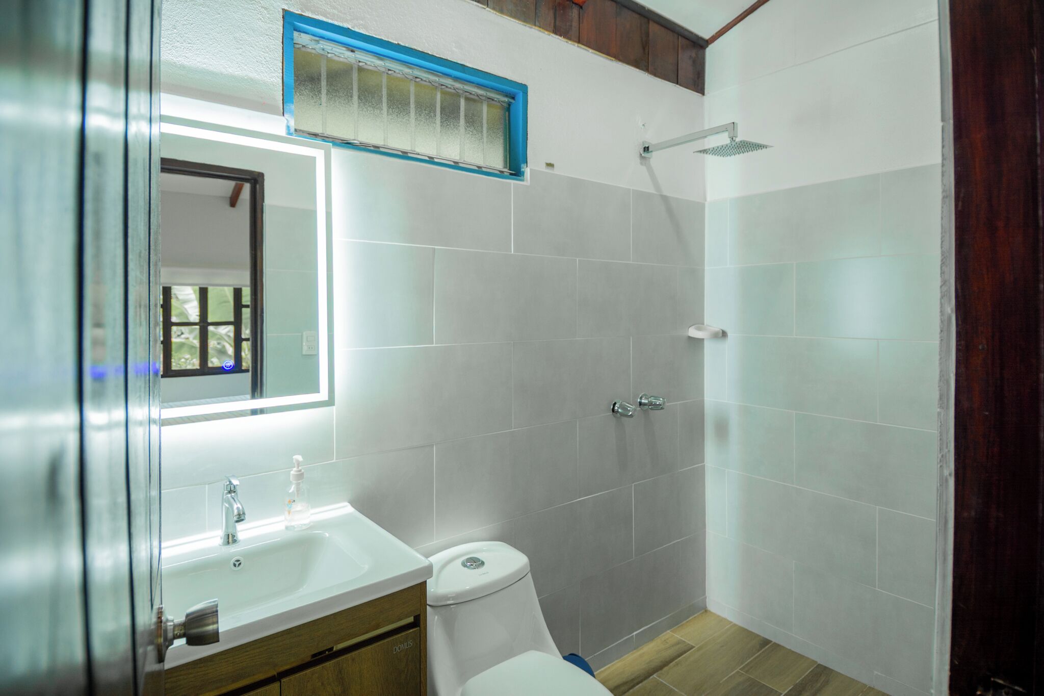 A bathroom with a white sink, mirror, and toilet.