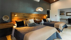 Un dormitorio moderno con dos camas, cabeceros de madera, mesitas de noche y una lámpara colgante.