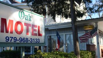 Segnaletica di motel con la scritta 'Oak Motel' e un numero di telefono.