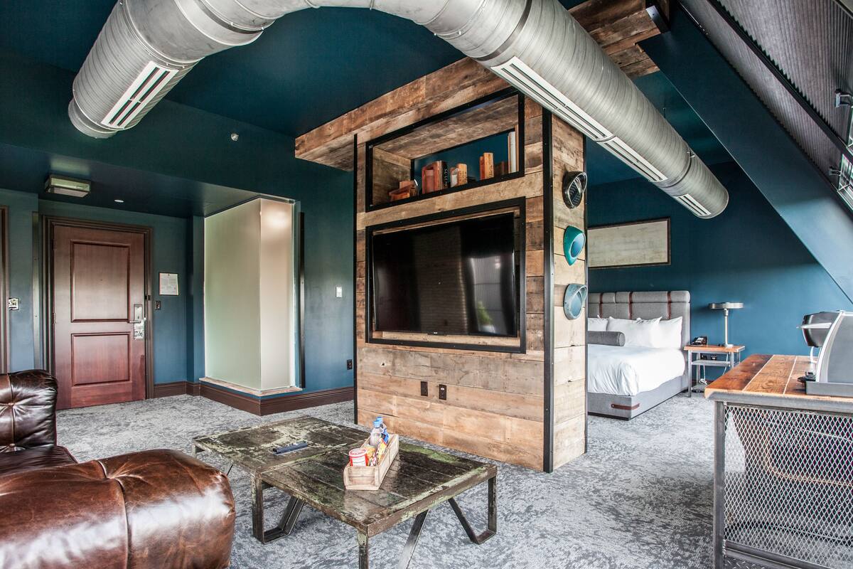 Ein Zimmer mit Heemsbett, Fernseher und einer Holz-Unterhaltungseinheit.
