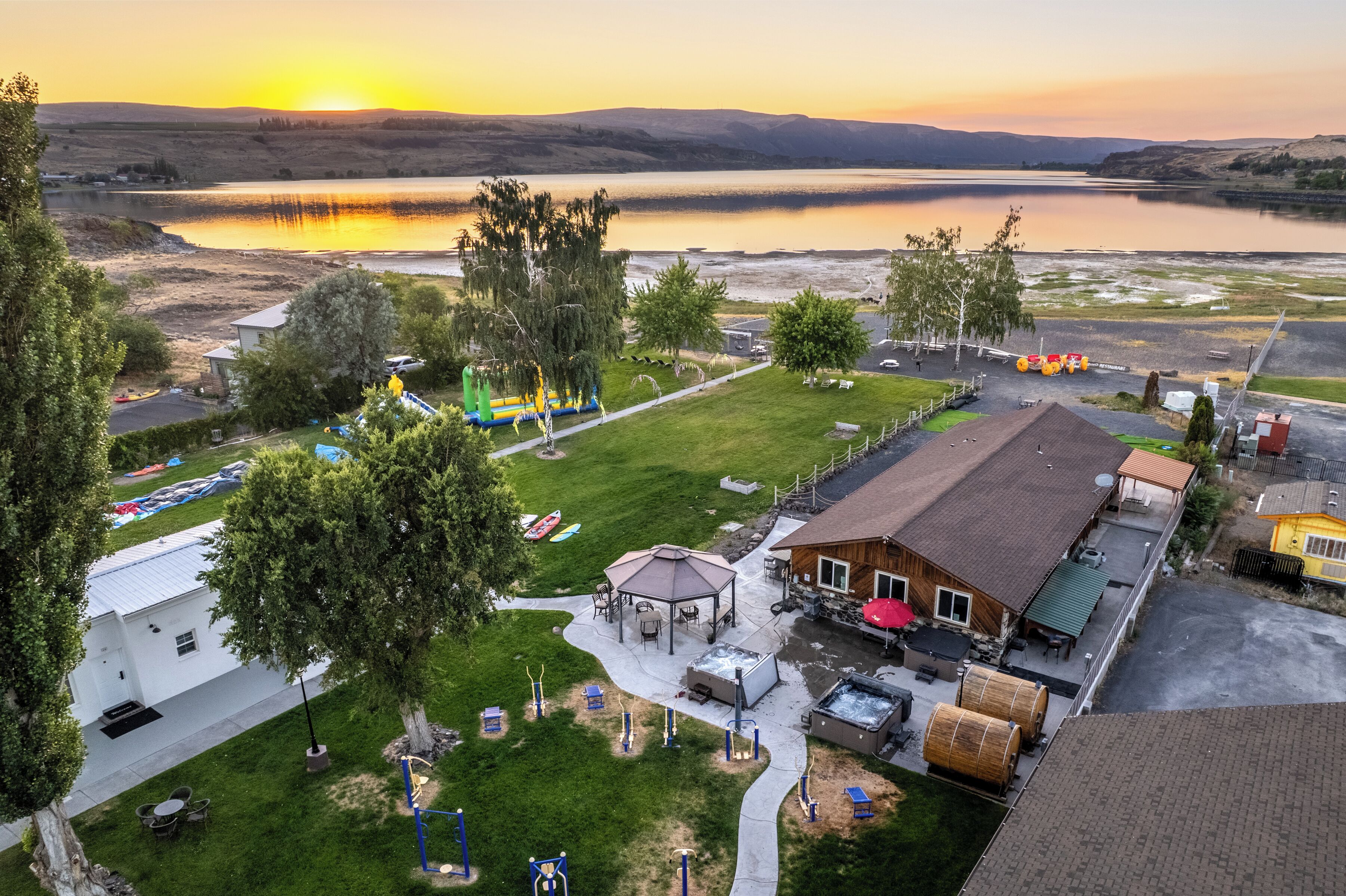 Una propiedad junto al lago con un pabellón, mobiliario exterior y una piscina.