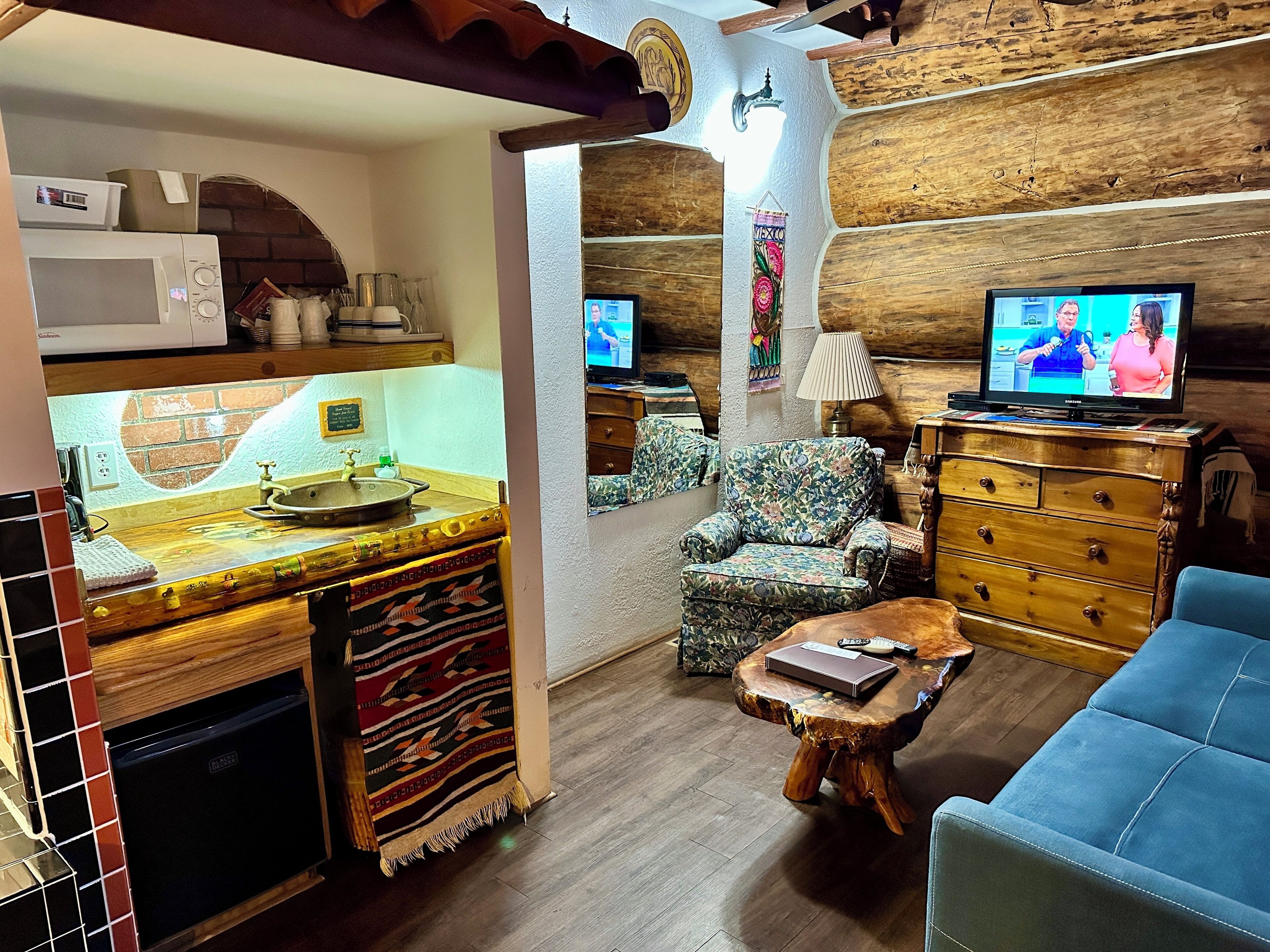 Un accogliente soggiorno con arredamento in legno, una televisione, un divano e un tavolino.