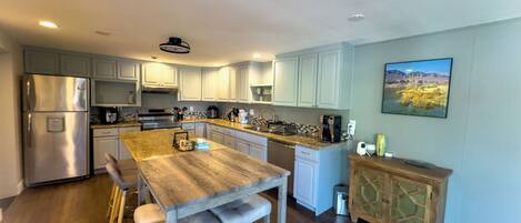 Una cocina moderna con una isla de madera, electrodomésticos de acero inoxidable y armarios azul claro.