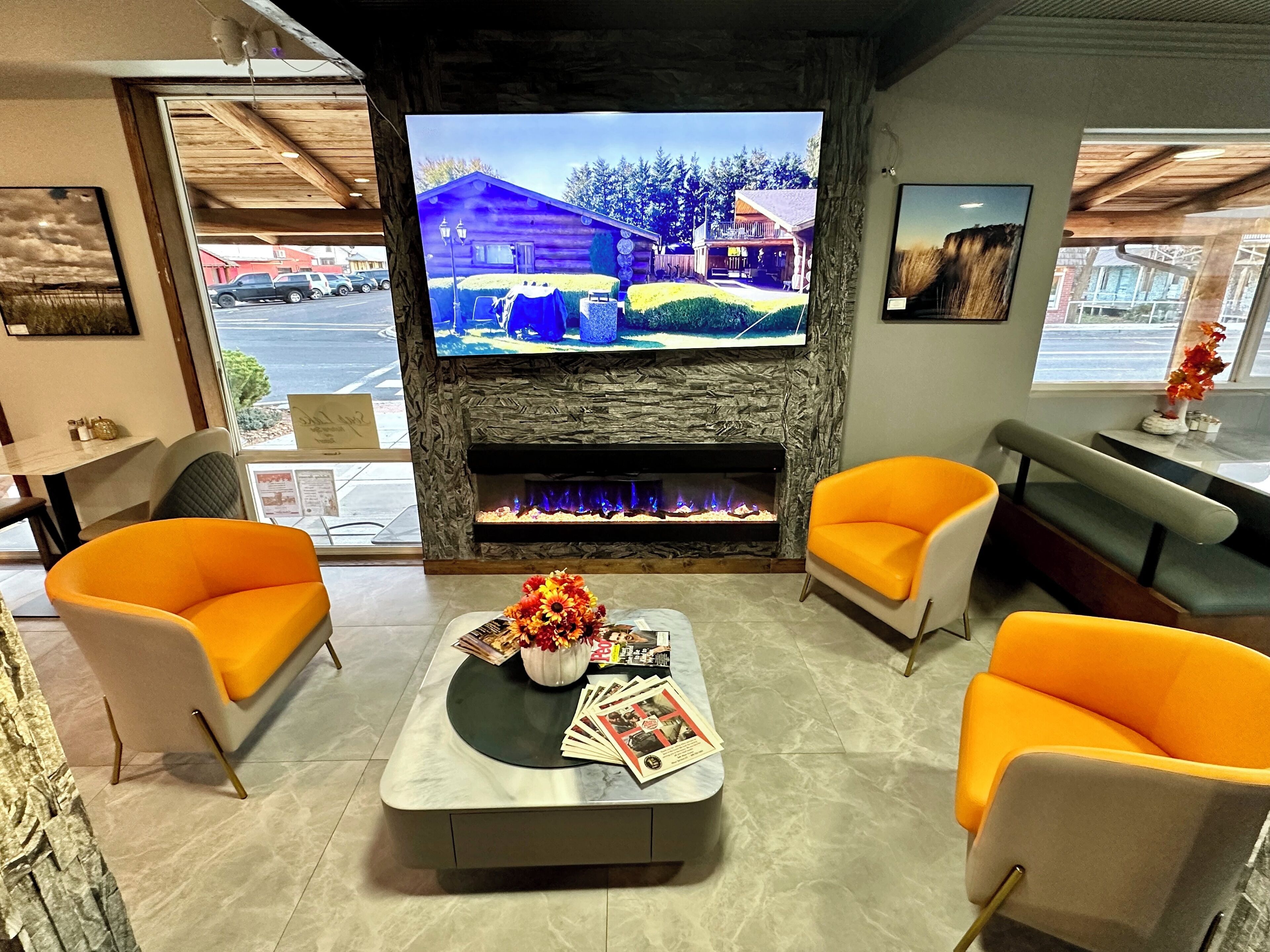 Una sala de estar moderna con chimenea, televisor y sillones naranjas.