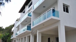 Un immeuble à plusieurs étages doté de balcons et d’un espace d’entrée abrité.