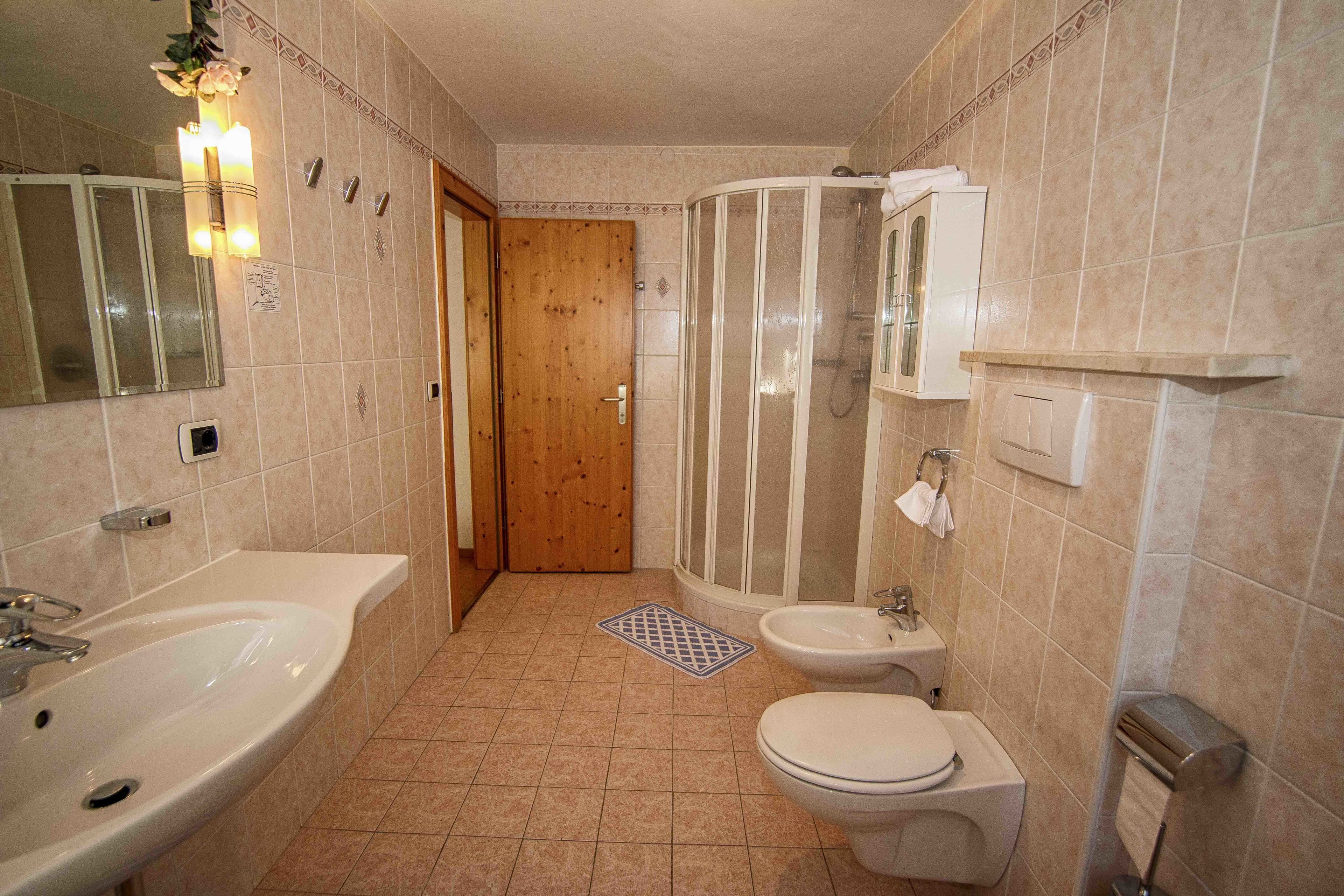 Un baño con lavamanos, inodoro y ducha.
