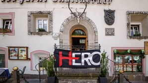 A building with a sign reading "garni Snaltnerhof" and a banner with "HERO" on it.