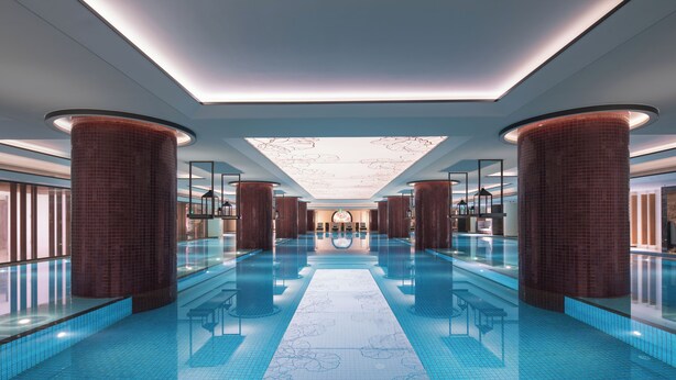 A spacious indoor swimming pool with a central walkway, surrounded by columns and glass railings. - Ascott Riverside Garden Beijing (Beijing)