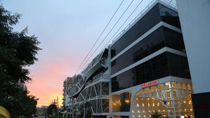 Un edificio moderno con fachada de vidrio y una alfombra roja que conduce a la entrada.