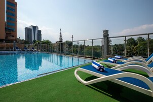 Una piscina al aire libre, sillones reclinables de piscina