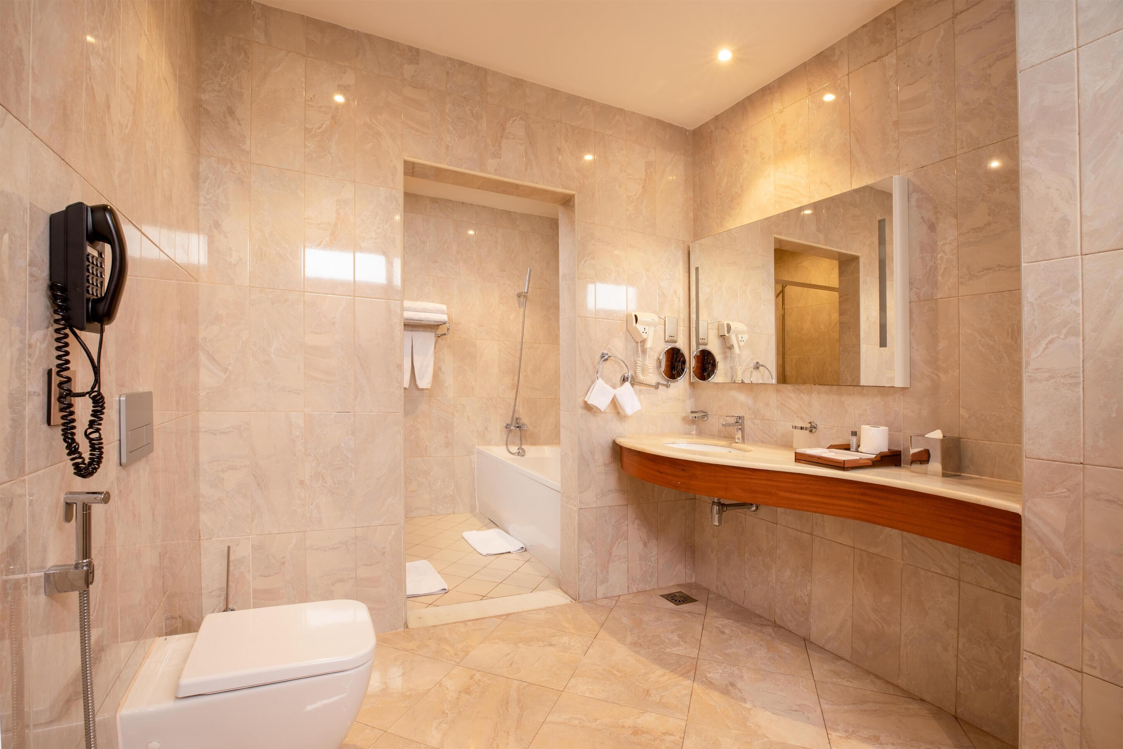 Un baño moderno con inodoro, lavamanos y ducha.