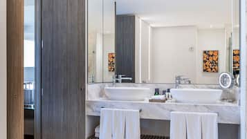 Un baño moderno con dos lavamanos, un espejo grande y un perchero para toallas.