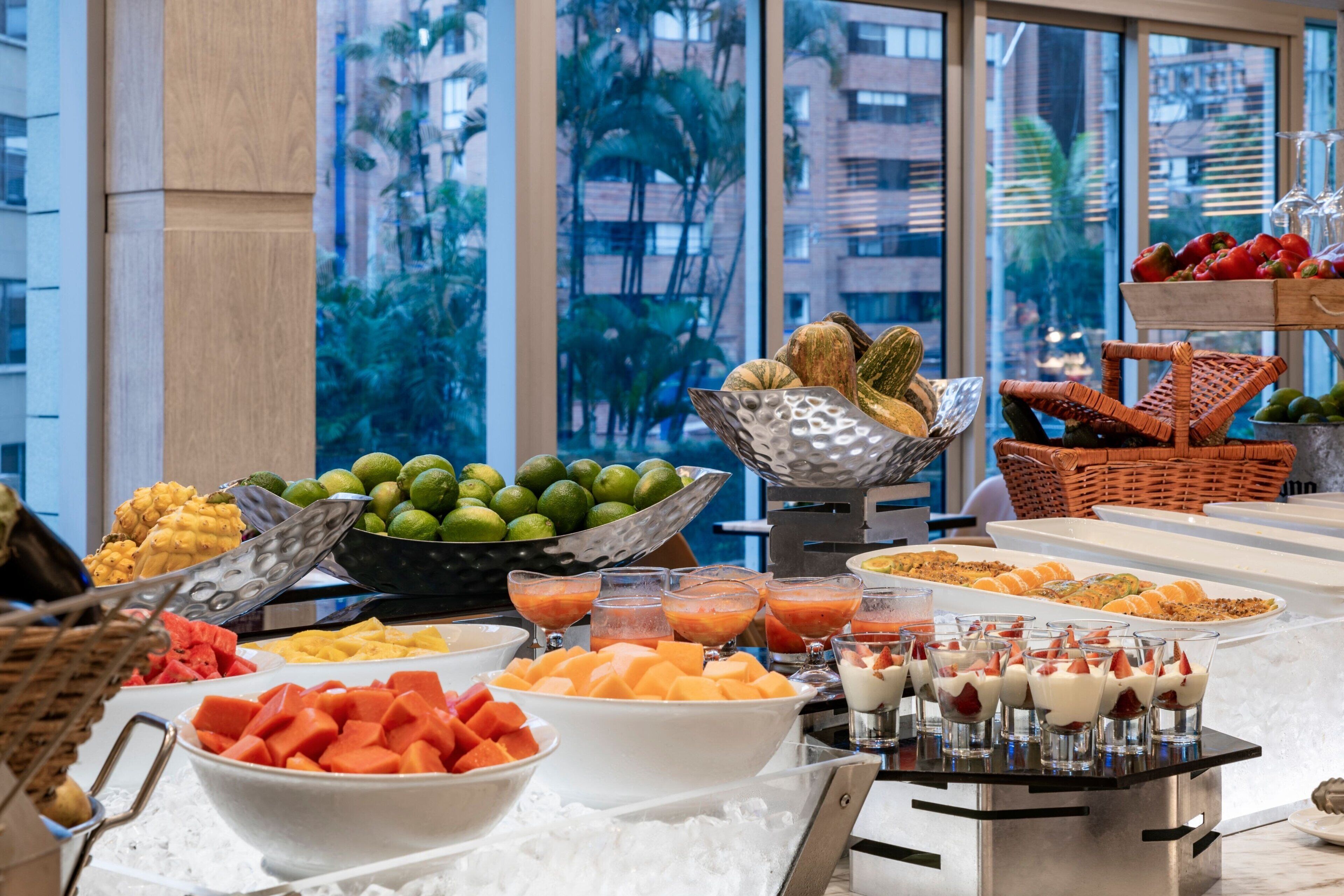 A buffet with various fruits, vegetables, and desserts.