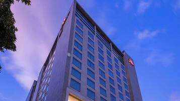 A modern hotel with a prominent entrance, large windows, and a well-lit facade.