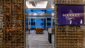 Un intérieur moderne comprenant une cave à vin, un coin repas et un grand mur de verre donnant sur la ville.
