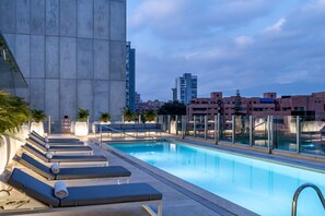 Una piscina al aire libre, tumbonas