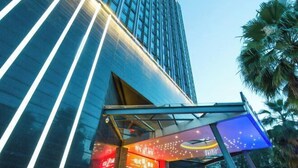 En modern byggnad med en entré av glas och upplyst skyltning.
