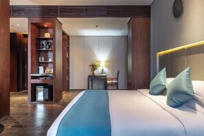 A hotel room with a bed, bedside table, lamp, and a built-in wardrobe. - Le Noble Hotel (Ganzhou City)