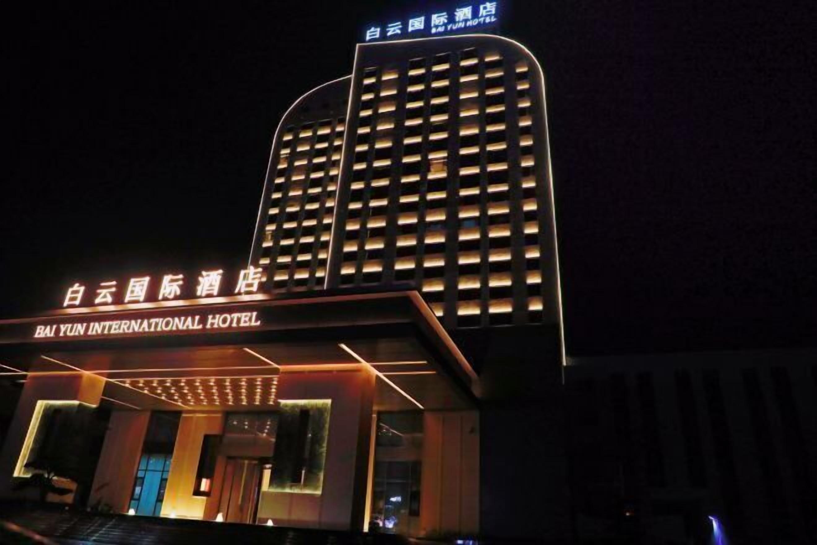 El Hotel Bai Yun International de noche, con señalización iluminada y una fachada moderna.