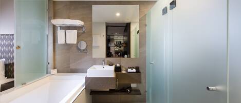 Une salle de bain moderne avec une douche à parois de verre, un lavabo blanc et un miroir au-dessus.