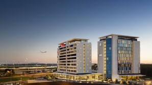 Een modern hotel met een plat dak, meerdere verdiepingen en een opvallend Pullman logo.