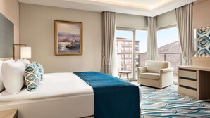 Een hotelkamer met een bed, een bureau, een stoel en uitzicht.