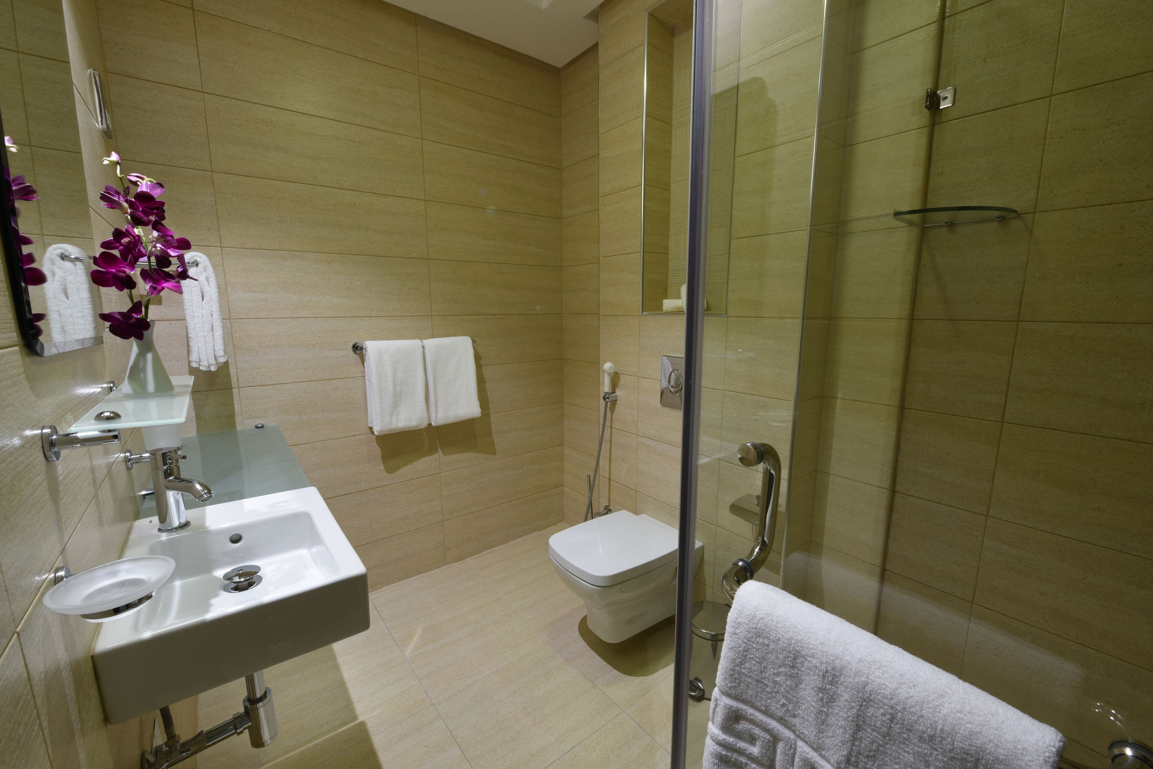 Een moderne badkamer met een wastafel, spiegel en douchecabine.