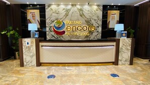 Un mostrador de recepción con encimera de mármol y un gran logotipo de Ramada Encore by Wyndham.