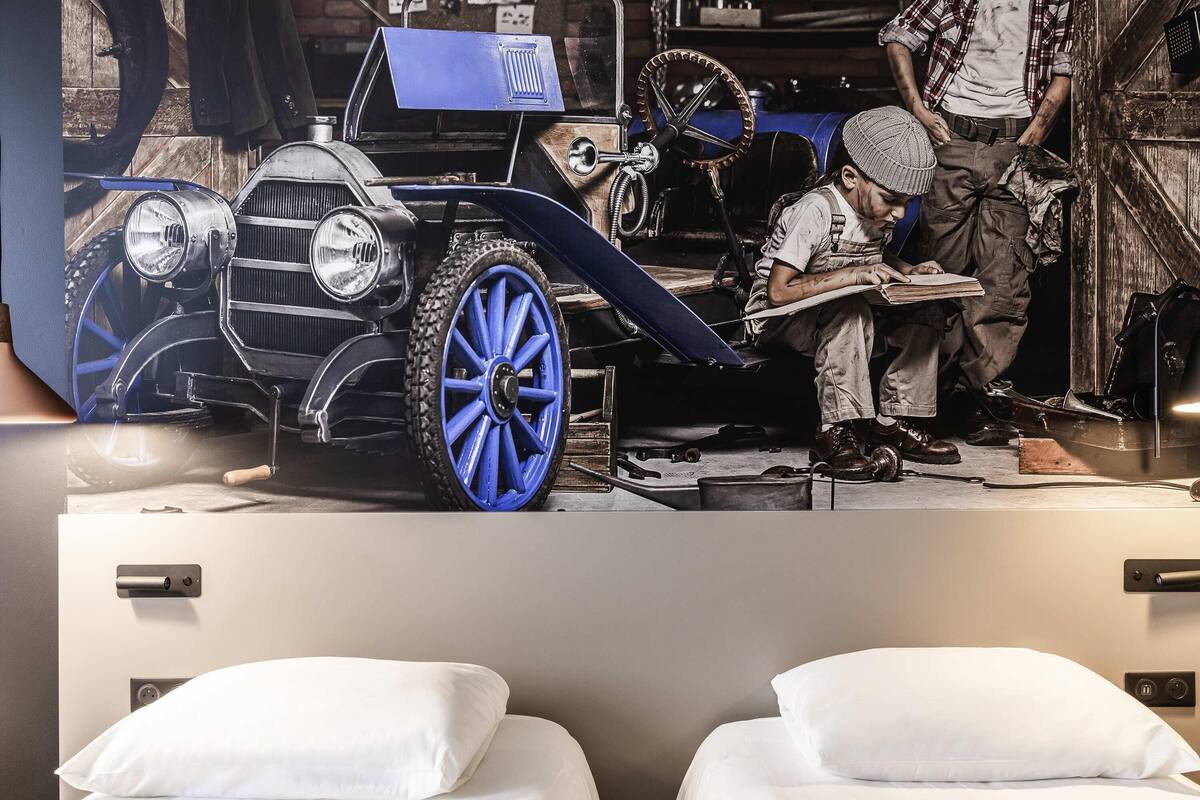 Een bed met wit beddengoed en een bedieningspaneel aan de muur.