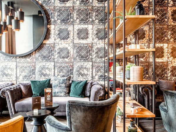 Un intérieur moderne avec un canapé en cuir, un miroir rond et une étagère en métal.
