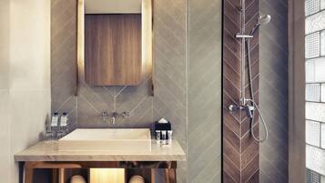 Ein Badezimmer mit Waschbecken, Spiegel, Handtuchhalter und Dusche.