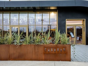 A modern building with a glass facade and the name "CHARBON" displayed prominently.