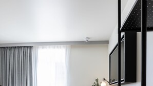 Une chambre d’hôtel moderne équipée d’un lit, d’un bureau, de chaises et d’un lit superposé.