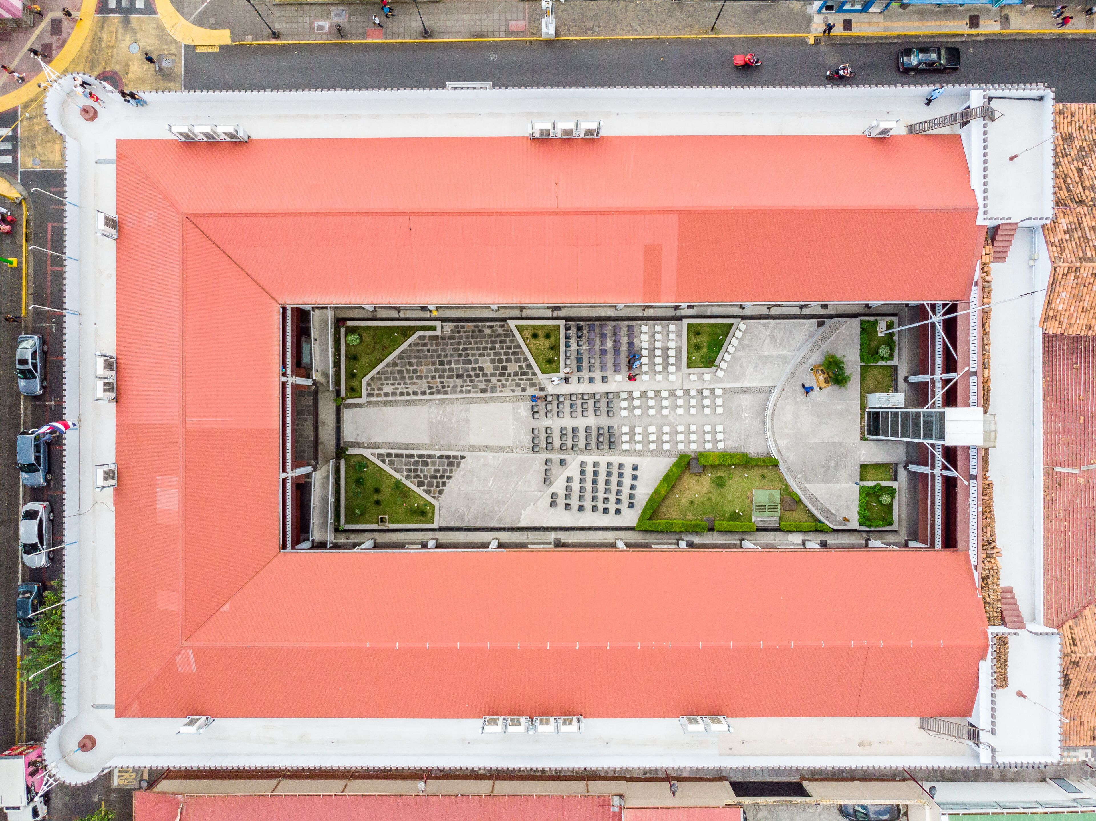 An aerial view of a stadium with a red roof, multiple seating sections, and a central field.