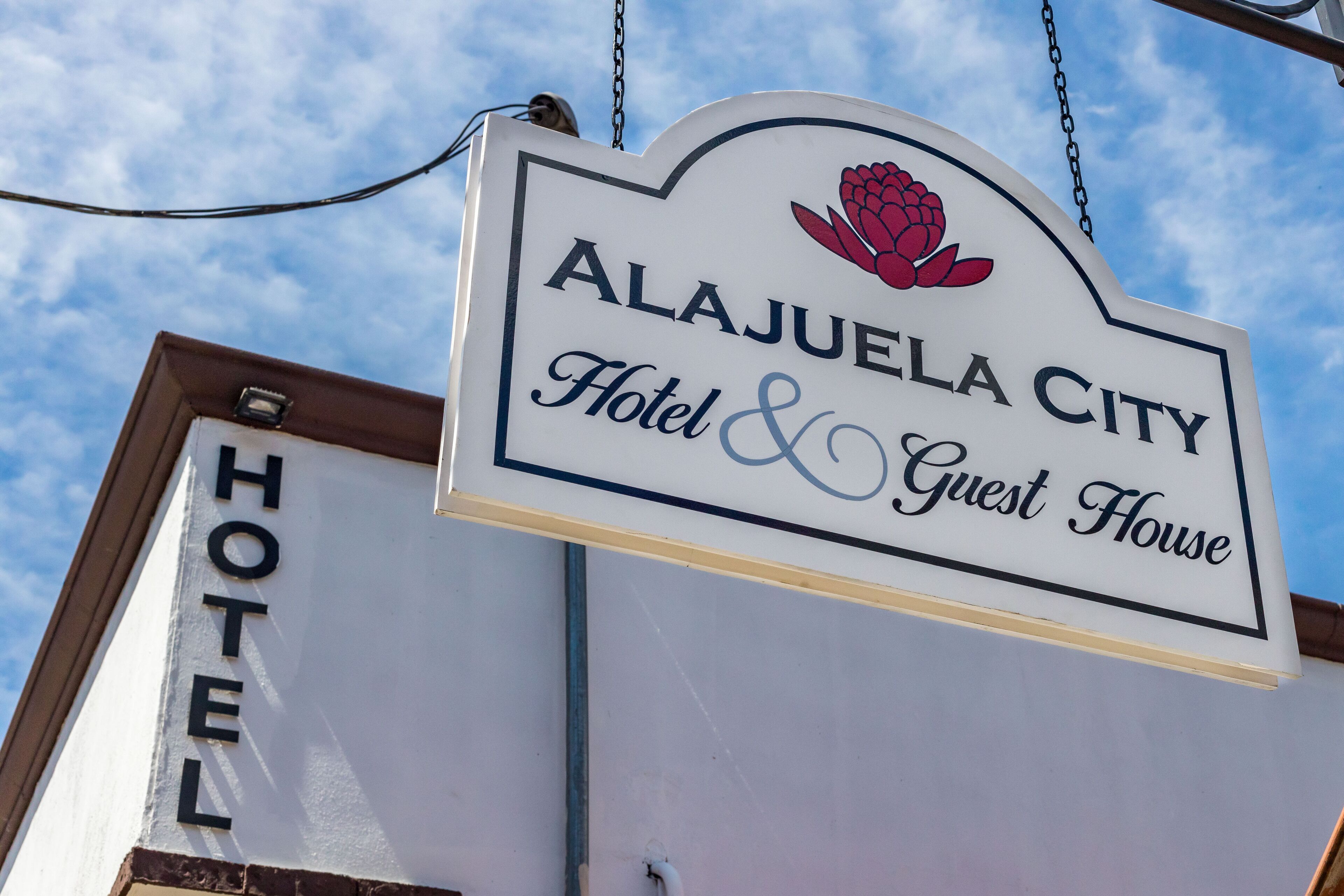 A sign for the Alajuela City Hotel & Guest House.