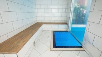 Relax in a clean and functional bathroom with a seating area and separate shower.