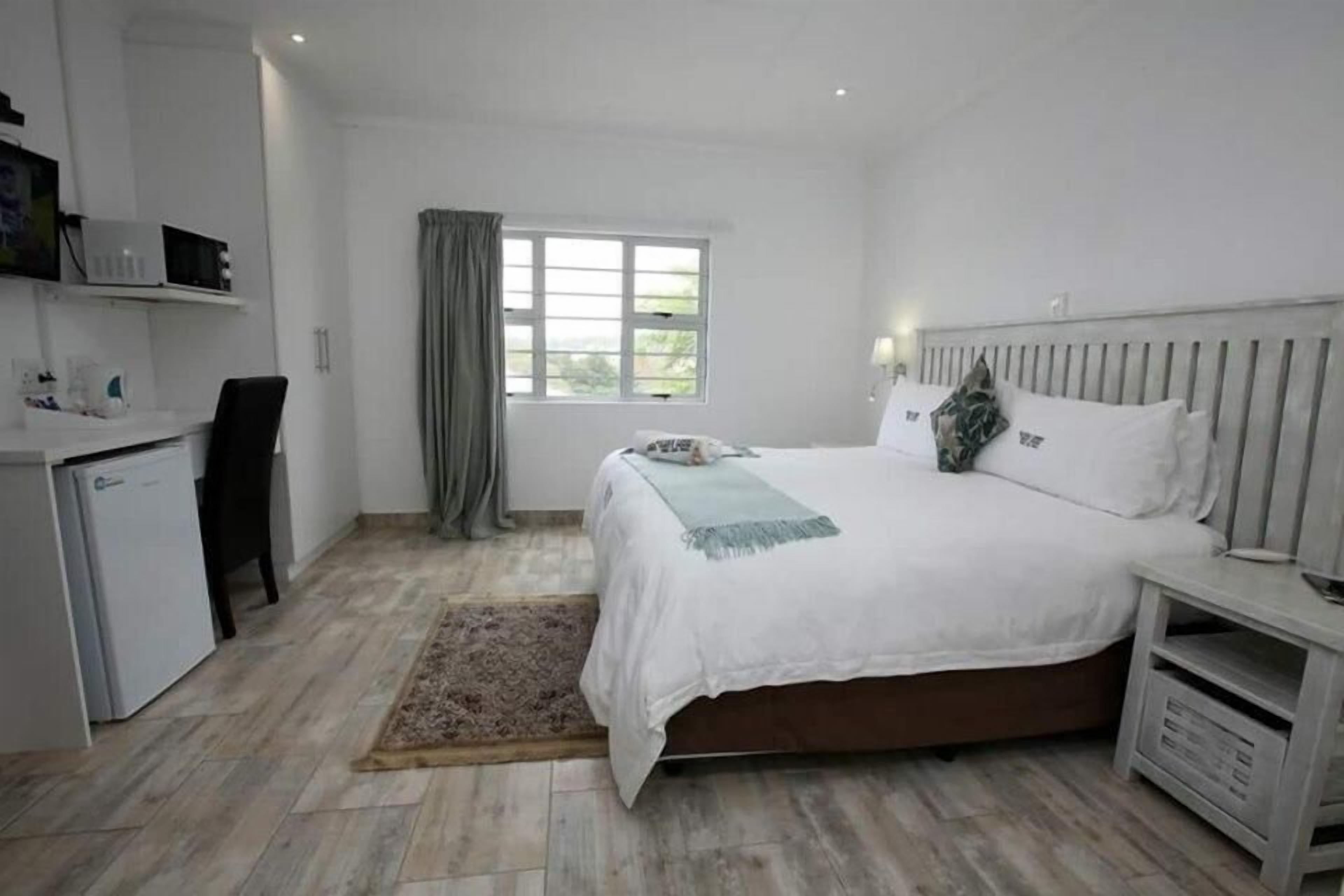 Ein Schlafzimmer mit Bett, Nachttisch und Fenster.