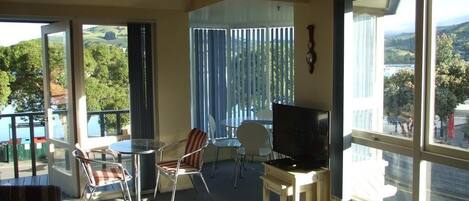 Appartement, 1 grand lit, balcon, vue sur la mer | Aire de séjour | Téléviseur de 60 po avec télévision par satellite