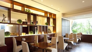 A modern dining area with wooden paneling, multiple tables, and chairs. - Rembrandt Hotel Oita (Oita)