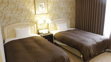 Ein Hotelzimmer mit zwei Betten, einem Nachttisch mit Lampe und einem gerahmten Bild an der Wand.