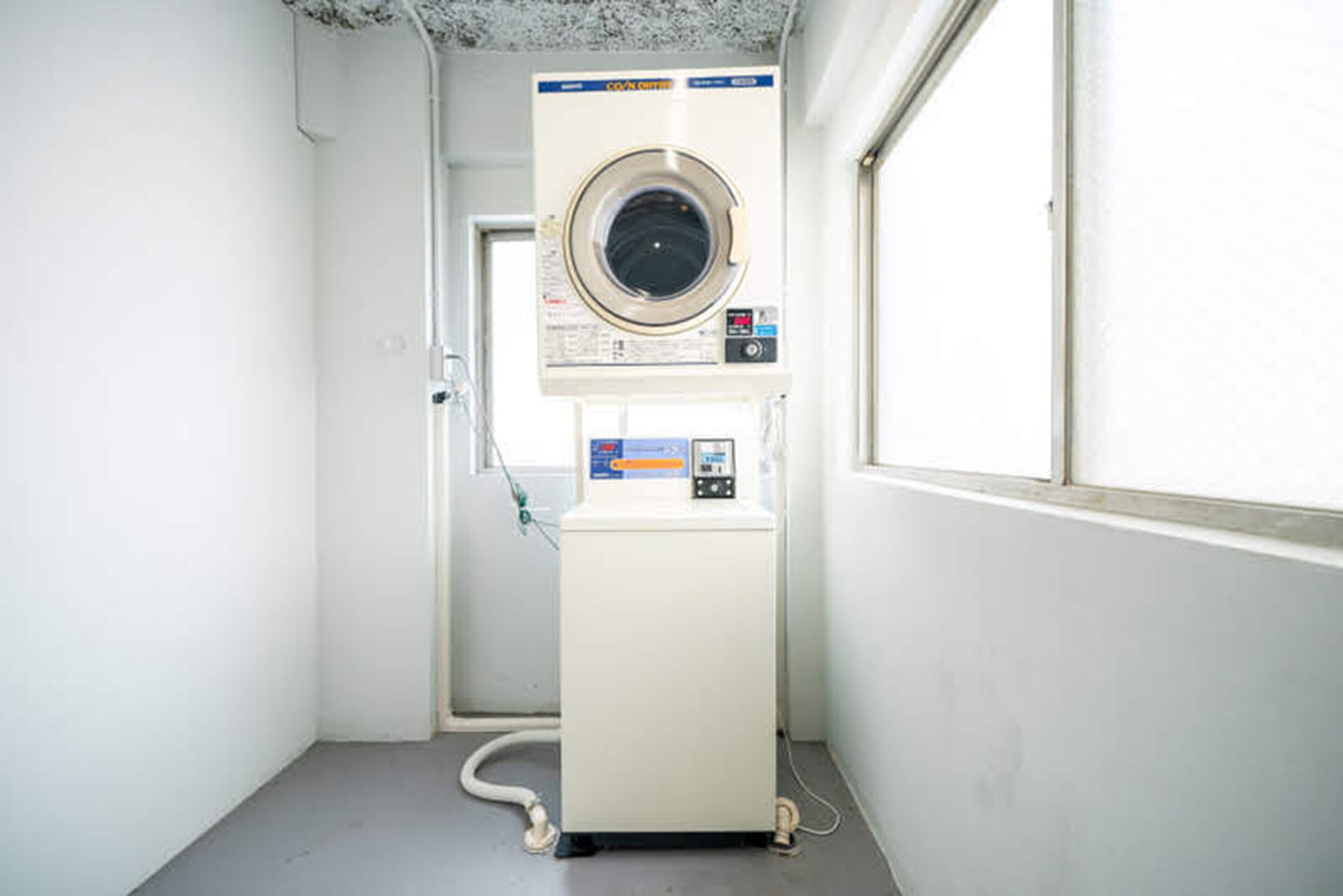 A compact, white laundry room with a front-loading washing machine and a dryer.