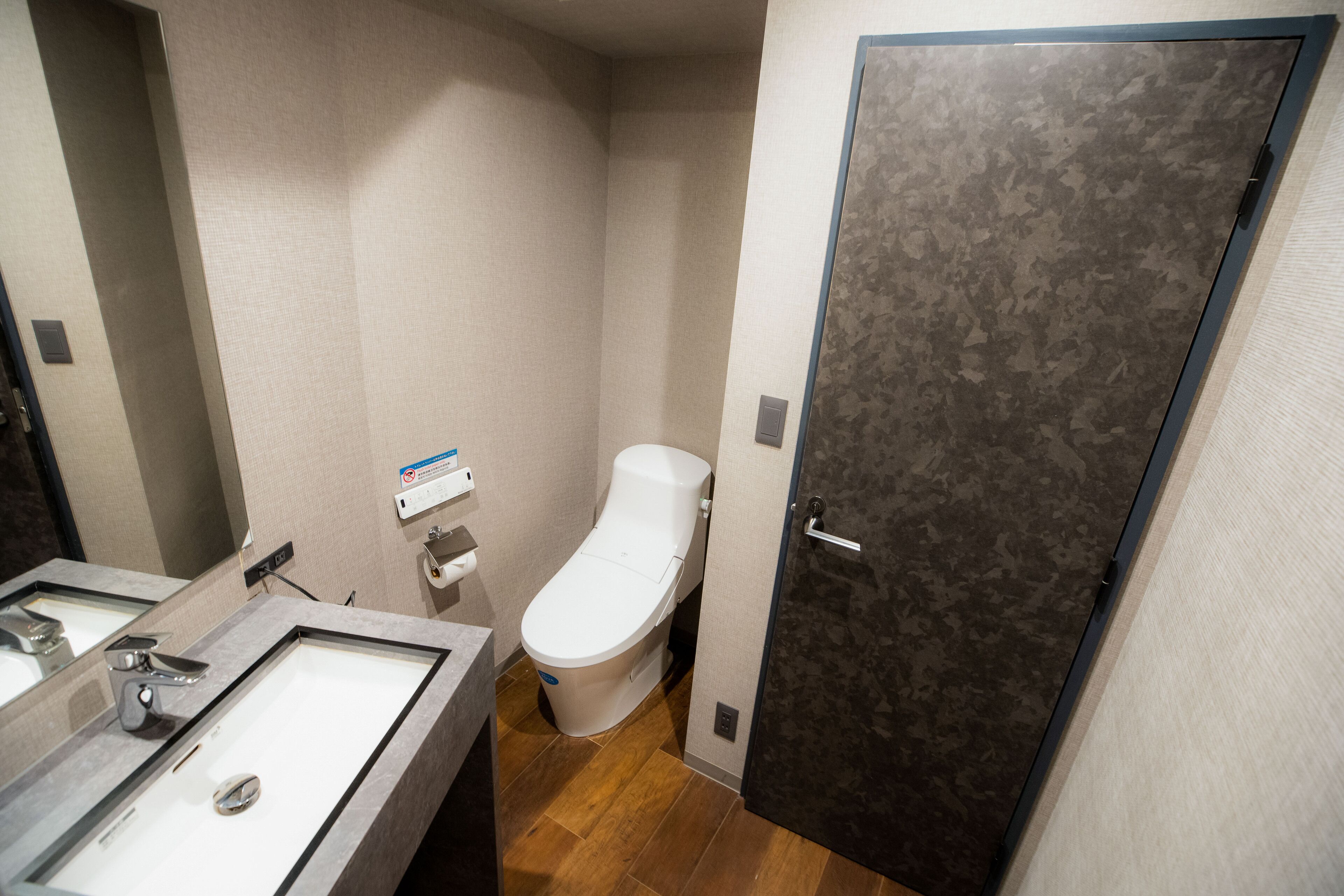 Une petite salle de bain avec des toilettes, un lavabo et un miroir.