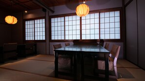 Une pièce de style japonais traditionnel, avec un sol recouvert de tatamis, une table basse et des paravents en papier de riz (shoji).