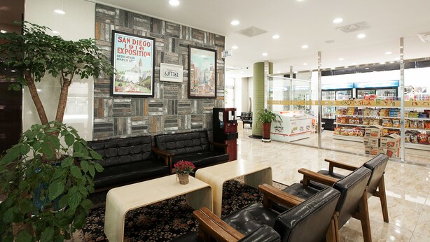 A hotel lobby with a seating area, a reception desk, and a display of local snacks.