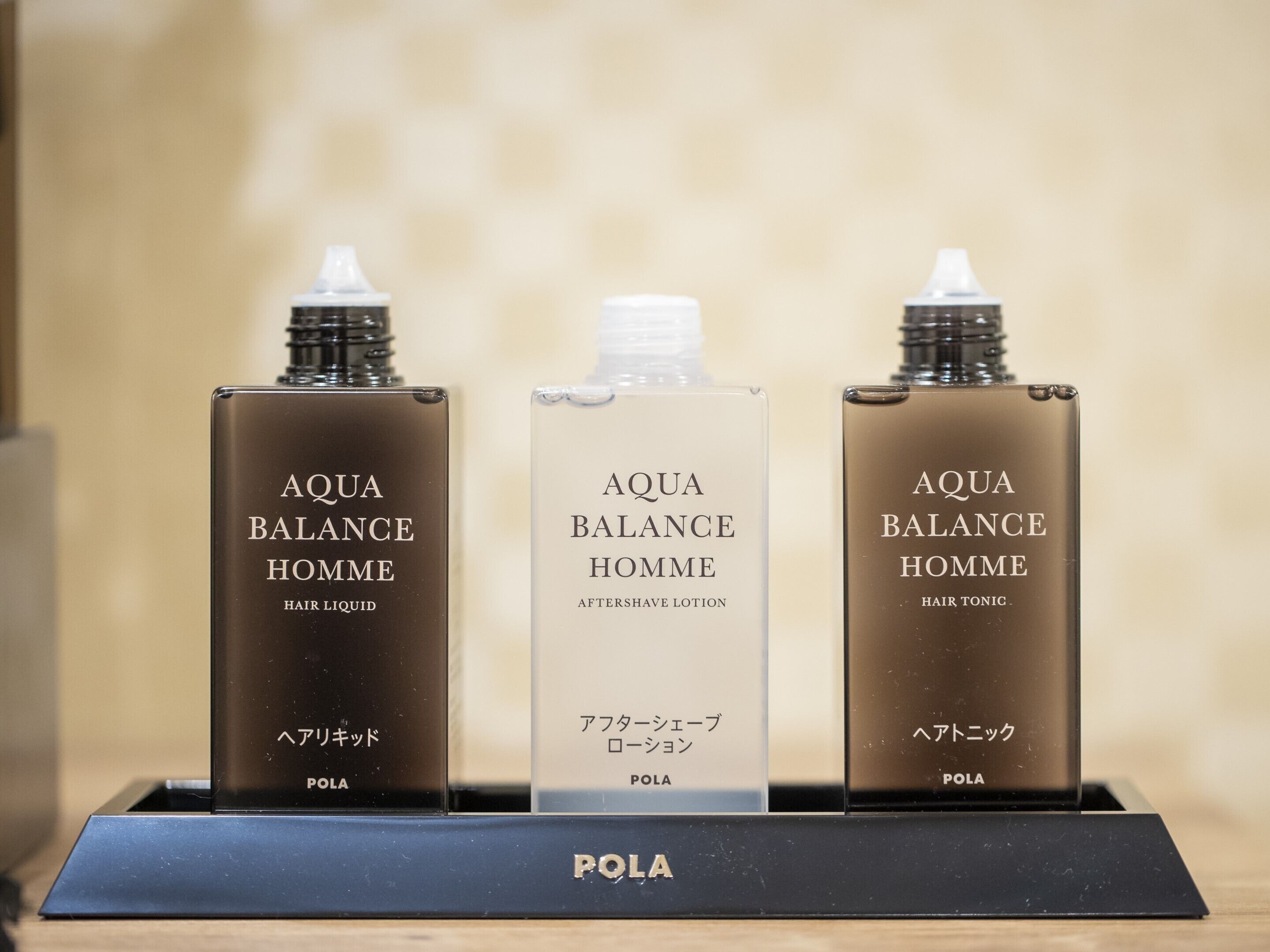 Three bottles of Aqua Balance Homme on a display stand.