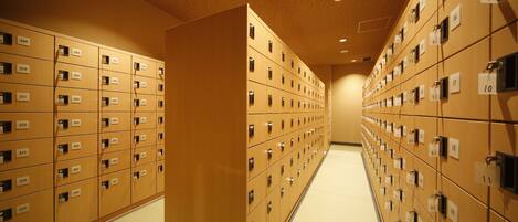 A hotel corridor with rows of numbered lockers.