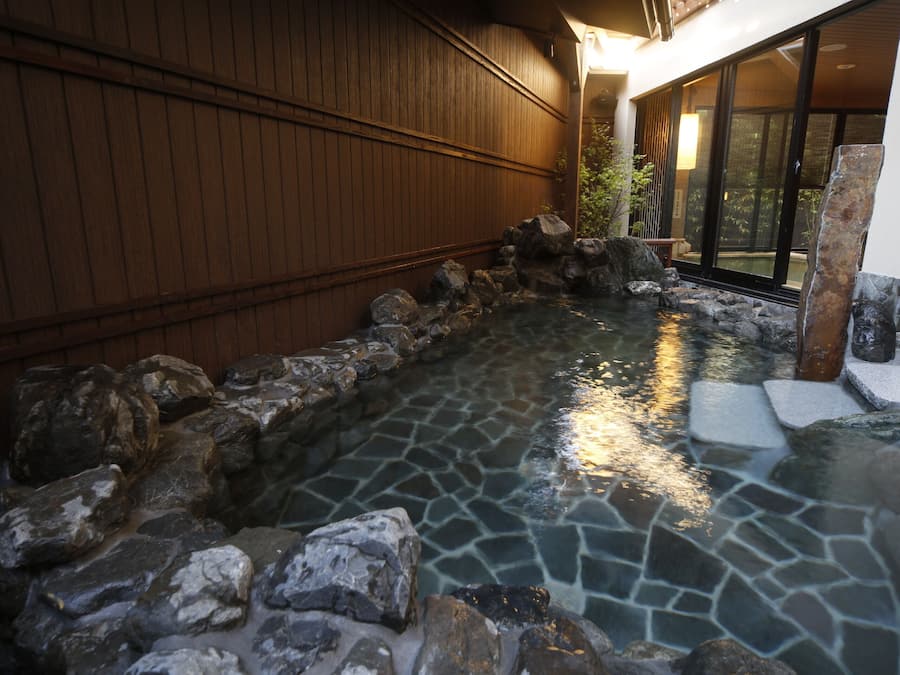 A hot spring area with stone tiles and rocks.