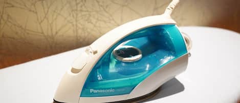 A Panasonic iron with a transparent water tank, placed on a white surface.