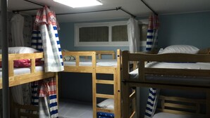A dormitory room with bunk beds, a window with curtains, and a ceiling light. - Housetay Guesthouse 2nd Branch - Hostel (Seoul)