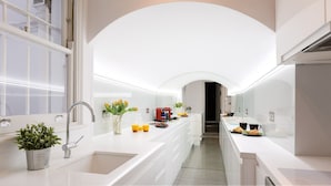 A modern kitchen with white cabinetry, a stainless steel sink, and a red coffee machine. - GREAT LOCATION -  Luxurious Knightsbridge Apartment - Steps from Harrods (London)